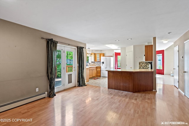 10321 Compass Cir, Anchorage, AK 99515 - kitchen featuring white fridge with ice dispenser, light wood-style floors, a peninsula, a baseboard heating unit, and decorative backsplash