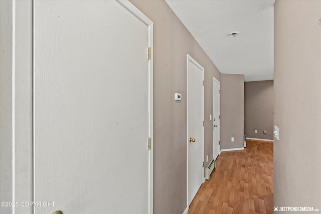 10321 Compass Cir, Anchorage, AK 99515 - hallway featuring light wood-type flooring, a baseboard heating unit, and baseboards