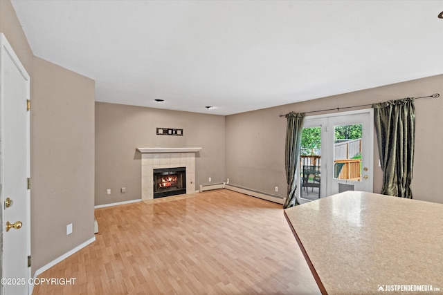 10321 Compass Cir, Anchorage, AK 99515 - unfurnished living room with a baseboard radiator, light wood-style flooring, a tile fireplace, baseboards, and baseboard heating