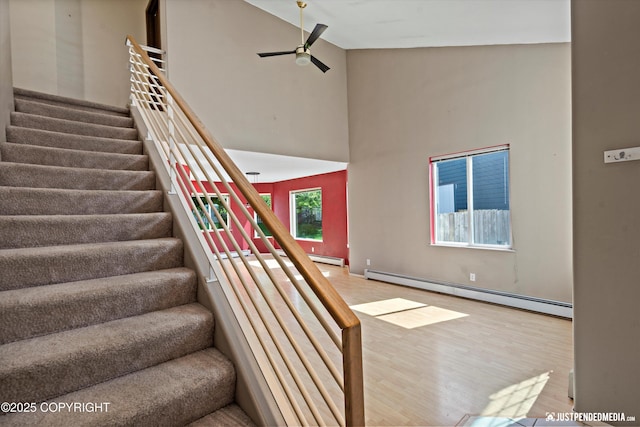 10321 Compass Cir, Anchorage, AK 99515 - staircase with high vaulted ceiling, a baseboard radiator, ceiling fan, and wood finished floors