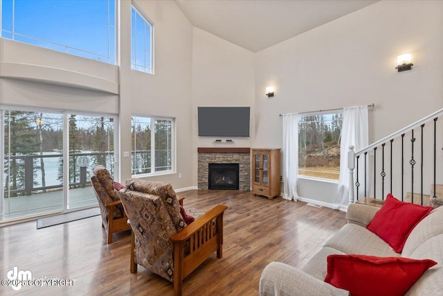 53578 Bell Ave, Nikiski/North Kenai, AK 99611 - living room with high vaulted ceiling, wood finished floors, a fireplace, baseboards, and stairs