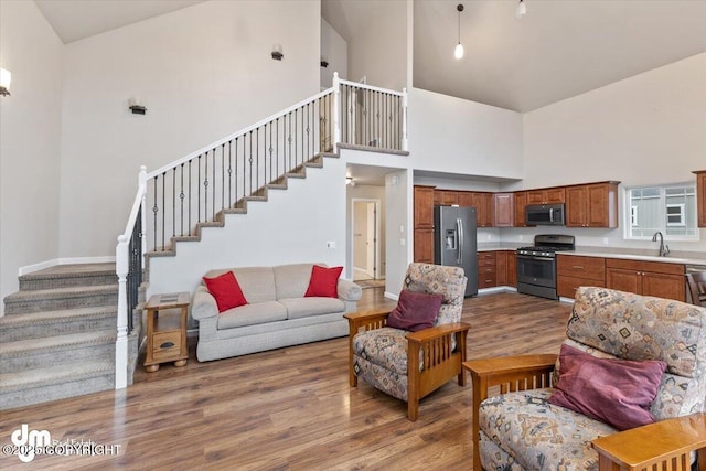 53578 Bell Ave, Nikiski/North Kenai, AK 99611 - living room featuring high vaulted ceiling, wood finished floors, stairs, and baseboards