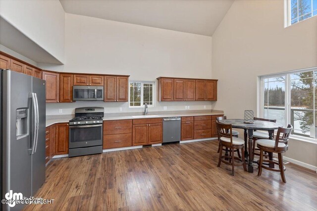 53578 Bell Ave, Nikiski/North Kenai, AK 99611 - kitchen featuring stainless steel appliances, high vaulted ceiling, a sink, and brown cabinetry