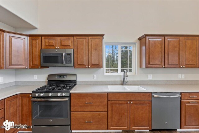53578 Bell Ave, Nikiski/North Kenai, AK 99611 - kitchen with appliances with stainless steel finishes, a sink, brown cabinetry, and light countertops