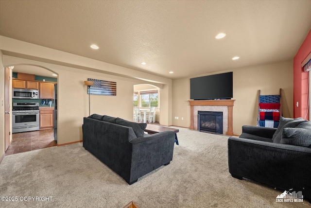241 N Pasture Pl, Palmer, AK 99645 - living area with light colored carpet, recessed lighting, arched walkways, a tiled fireplace, and baseboards