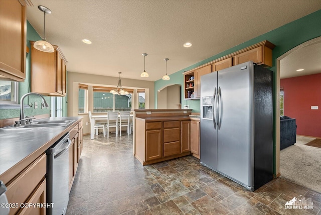 241 N Pasture Pl, Palmer, AK 99645 - kitchen with stainless steel appliances, a sink, arched walkways, a chandelier, and a textured ceiling