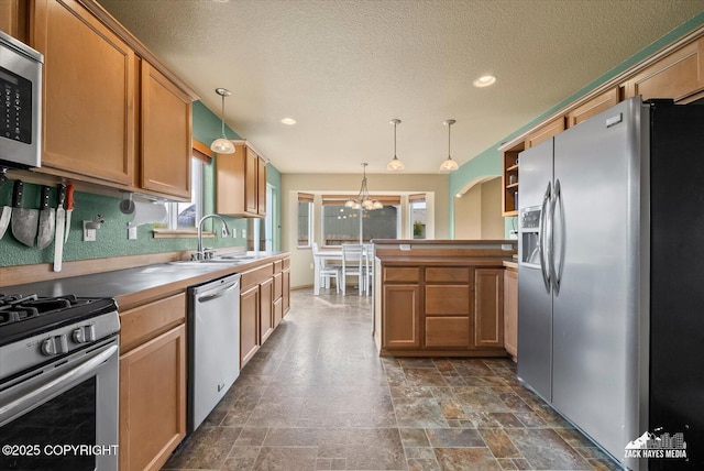 241 N Pasture Pl, Palmer, AK 99645 - kitchen with stainless steel appliances, a chandelier, a sink, a textured ceiling, and pendant lighting