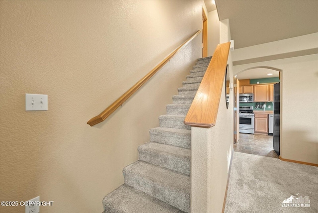 241 N Pasture Pl, Palmer, AK 99645 - stairway featuring arched walkways, carpet flooring, and a textured wall