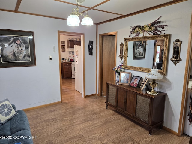 35515 King Salmon Ave, Soldotna, AK 99669 - corridor with light wood-type flooring, crown molding, a chandelier, and baseboards