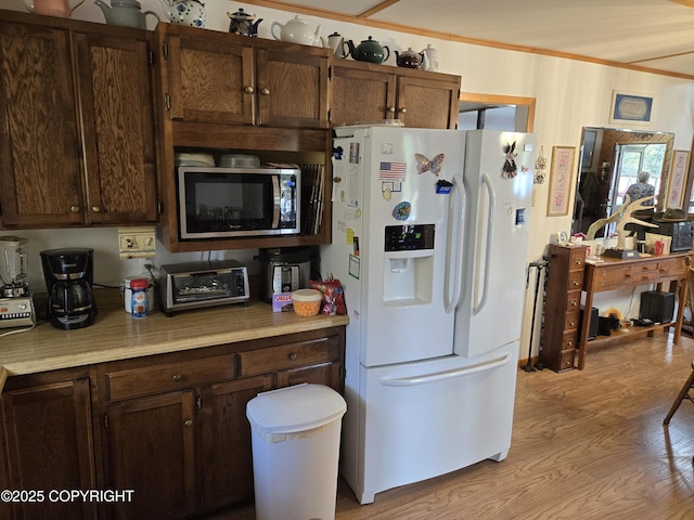 35515 King Salmon Ave, Soldotna, AK 99669 - kitchen with white fridge with ice dispenser, stainless steel microwave, light countertops, light wood finished floors, and crown molding