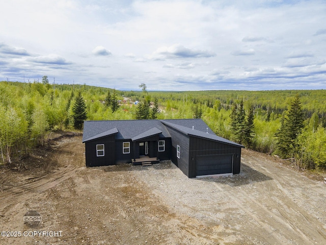 1866 S Rolling Hills St, Wasilla, AK 99623 - view of front of house featuring a garage, dirt driveway, and a forest view
