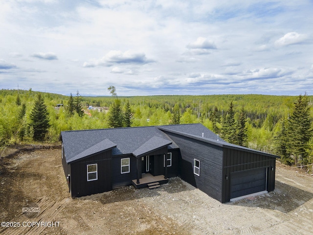 1866 S Rolling Hills St, Wasilla, AK 99623 - view of front facade with a wooded view, an attached garage, board and batten siding, and driveway