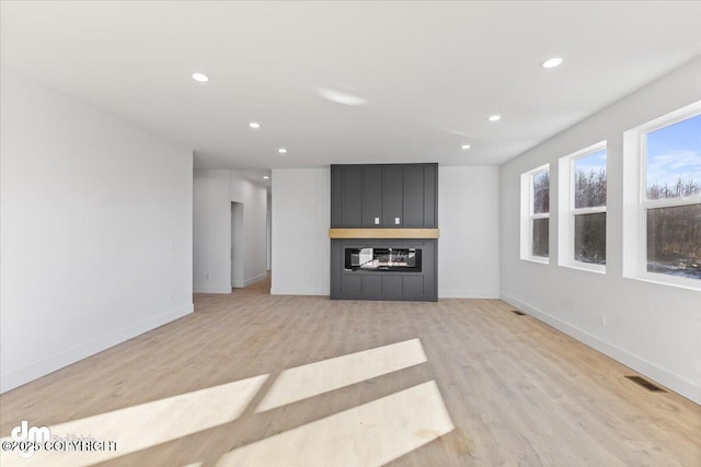 1866 S Rolling Hills St, Wasilla, AK 99623 - unfurnished living room with light wood-type flooring, recessed lighting, and baseboards