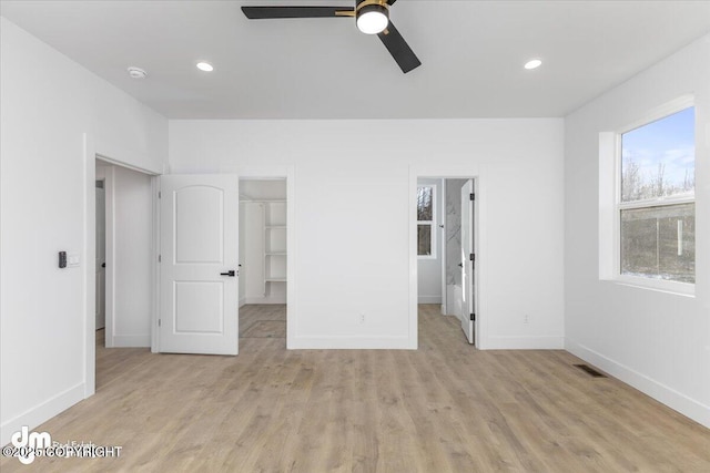 1866 S Rolling Hills St, Wasilla, AK 99623 - unfurnished bedroom featuring a walk in closet, baseboards, light wood-style floors, and recessed lighting