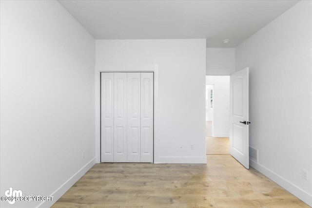 1866 S Rolling Hills St, Wasilla, AK 99623 - unfurnished bedroom with light wood-style flooring, baseboards, and a closet