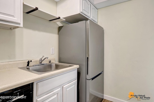 4640 Reka Dr Unit 19, Anchorage, AK 99508 - kitchen featuring dishwashing machine, a sink, and white cabinetry