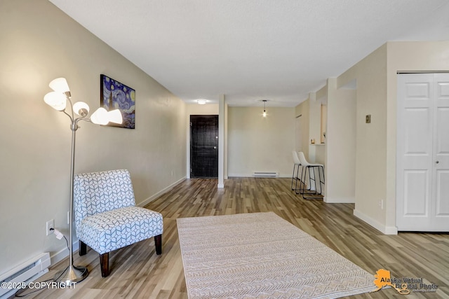 4640 Reka Dr Unit 19, Anchorage, AK 99508 - living area with a baseboard heating unit, wood finished floors, baseboards, and baseboard heating
