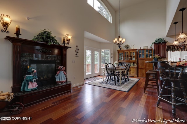 10885 Splendor Loop, Eagle River, AK 99577 - dining space with dark wood-style floors, a chandelier, a high ceiling, and a high end fireplace