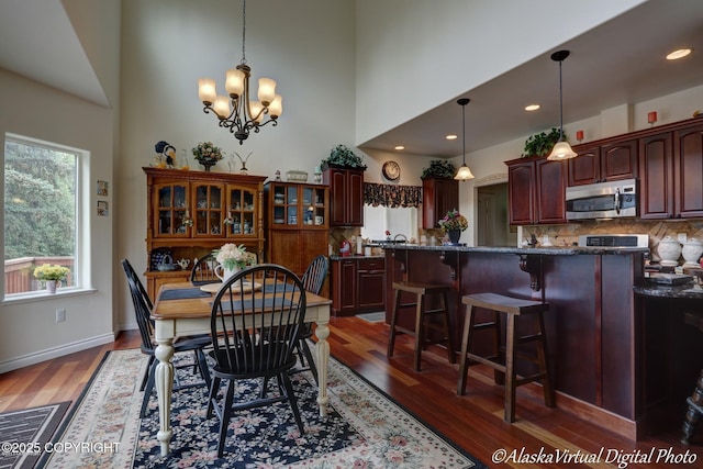10885 Splendor Loop, Eagle River, AK 99577 - dining room featuring wood finished floors, a chandelier, a high ceiling, and recessed lighting