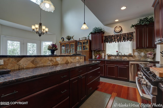 10885 Splendor Loop, Eagle River, AK 99577 - kitchen with a sink, stainless steel range with gas cooktop, a chandelier, tasteful backsplash, and pendant lighting