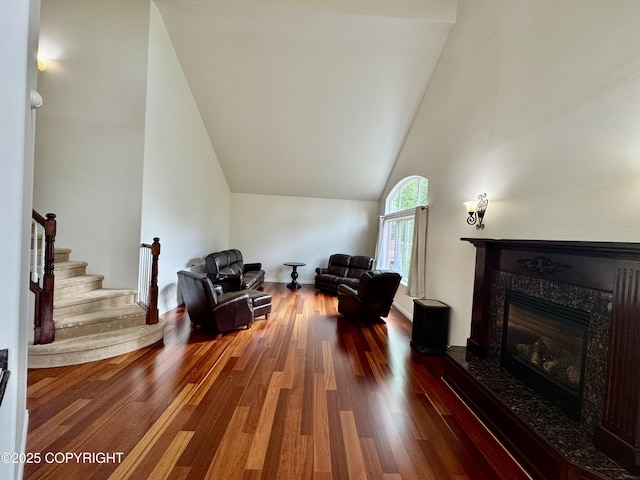 10885 Splendor Loop, Eagle River, AK 99577 - living area featuring wood finished floors, high vaulted ceiling, a high end fireplace, and stairway
