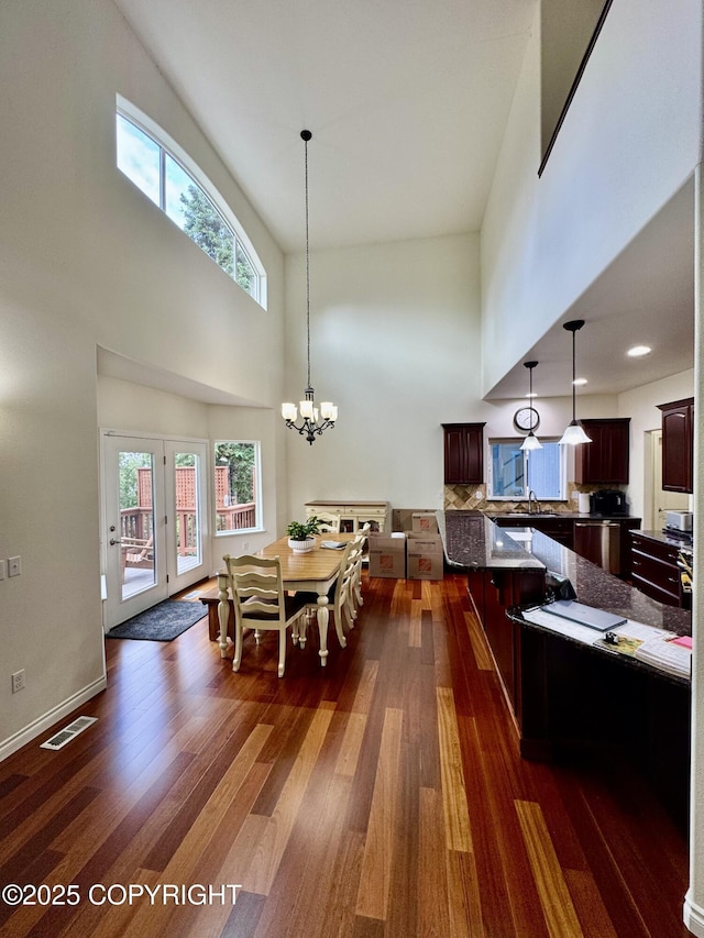 10885 Splendor Loop, Eagle River, AK 99577 - dining space featuring a towering ceiling, dark wood finished floors, and a chandelier