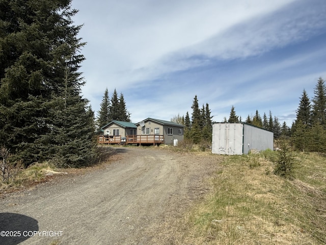 69290 Emily Ct, Ninilchik, AK 99556 - view of front facade with a wooden deck and dirt driveway