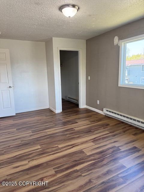 180 Grand Larry St Unit B6, Anchorage, AK 99504 - unfurnished room featuring baseboard heating, wood finished floors, a textured ceiling, and baseboards