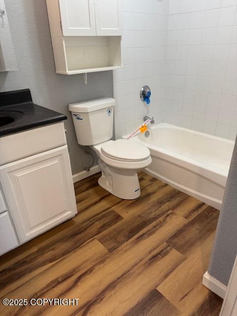 180 Grand Larry St Unit B6, Anchorage, AK 99504 - bathroom featuring toilet, vanity, wood finished floors, and bathtub / shower combination