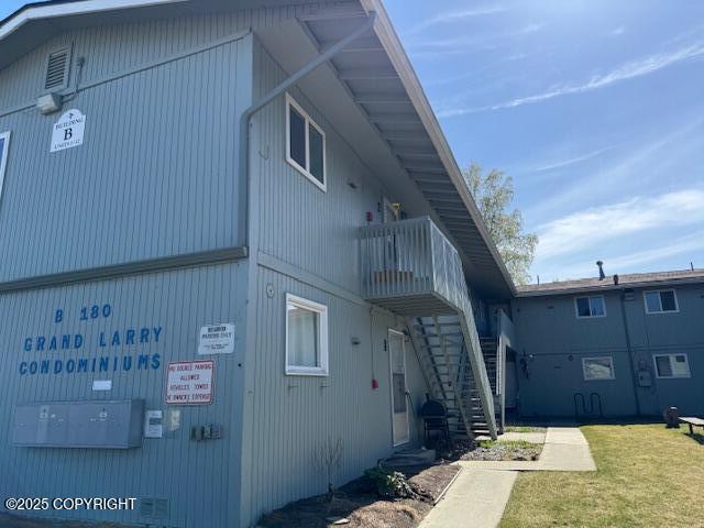 180 Grand Larry St Unit B6, Anchorage, AK 99504 - rear view of house featuring stairway, a balcony, and a yard
