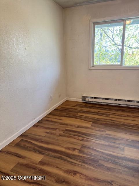 180 Grand Larry St Unit B6, Anchorage, AK 99504 - unfurnished room with a baseboard heating unit, baseboards, and dark wood-style floors