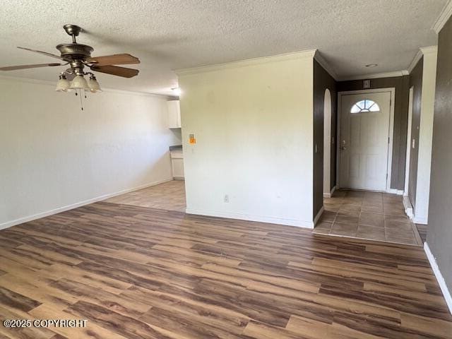 180 Grand Larry St Unit B6, Anchorage, AK 99504 - spare room featuring crown molding, arched walkways, wood finished floors, ceiling fan, and a textured ceiling