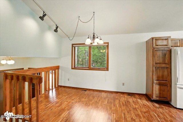 19254 Adak Cir, Eagle River, AK 99577 - spare room with a chandelier, wood-type flooring, rail lighting, and baseboards