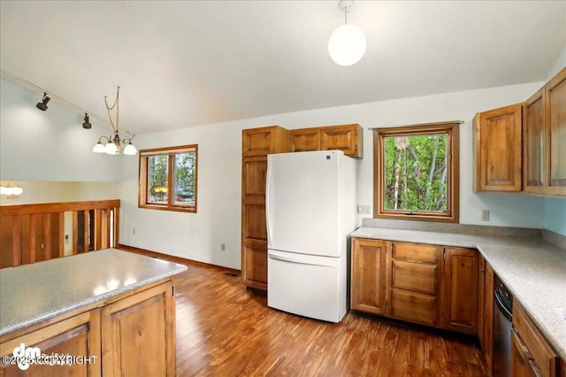 19254 Adak Cir, Eagle River, AK 99577 - kitchen featuring freestanding refrigerator, brown cabinetry, pendant lighting, wood finished floors, and a chandelier