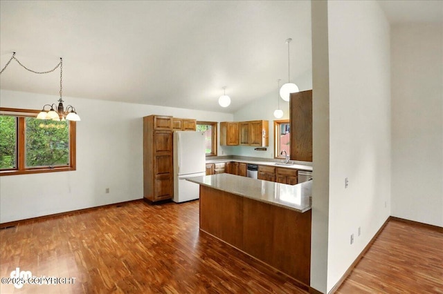 19254 Adak Cir, Eagle River, AK 99577 - kitchen with freestanding refrigerator, a sink, a peninsula, healthy amount of natural light, and vaulted ceiling
