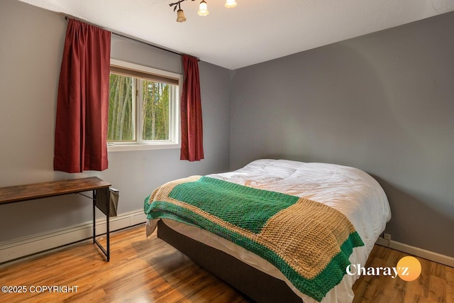 1147 Choctaw Rd, North Pole, AK 99705 - bedroom with wood finished floors, a baseboard heating unit, and baseboards