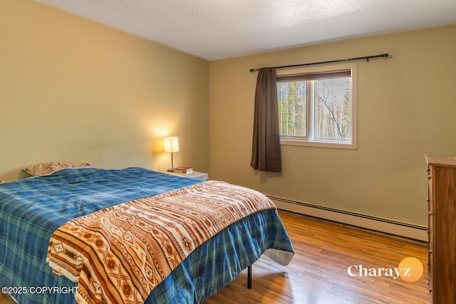 1147 Choctaw Rd, North Pole, AK 99705 - bedroom featuring a baseboard heating unit and wood finished floors