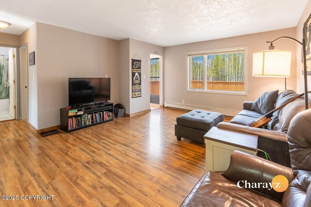 1147 Choctaw Rd, North Pole, AK 99705 - living room with light wood-style flooring, a baseboard heating unit, baseboards, and a textured ceiling