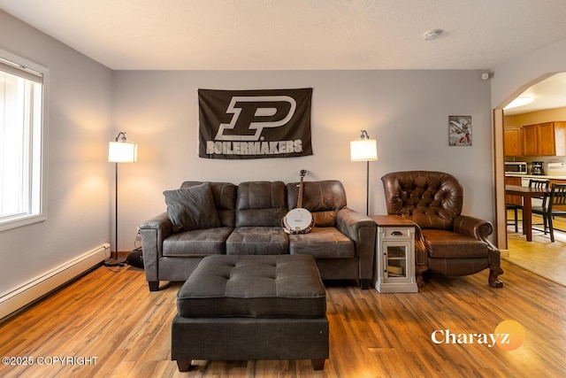 1147 Choctaw Rd, North Pole, AK 99705 - living area featuring arched walkways, baseboard heating, wood finished floors, and healthy amount of natural light