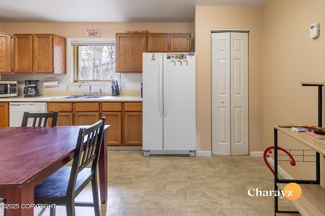 1147 Choctaw Rd, North Pole, AK 99705 - kitchen featuring white appliances, a sink, brown cabinets, and light countertops