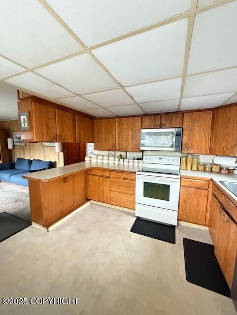 1411 Mission Rd, Kodiak, AK 99615 - kitchen featuring stainless steel microwave, white electric range, brown cabinetry, light countertops, and a peninsula