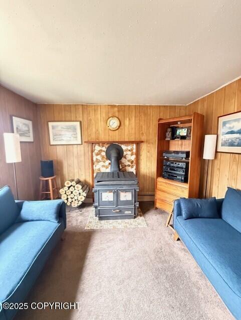 1411 Mission Rd, Kodiak, AK 99615 - living room featuring light carpet, a wood stove, and wood walls