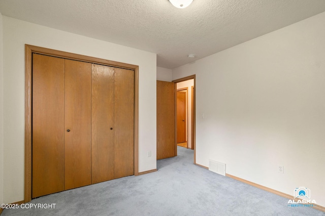 18113 Misty Falls Cir, Eagle River, AK 99577 - unfurnished bedroom with carpet floors, a closet, baseboards, and a textured ceiling