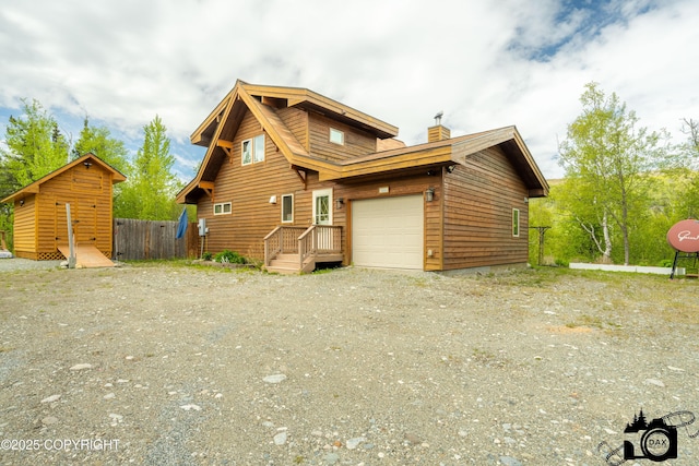 18365 E Twin Hills Ln, Sutton, AK 99645 - view of front facade with a garage, a chimney, and dirt driveway