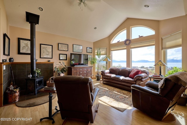 41293 Crested Crane St, Homer, AK 99603 - living area featuring a wood stove, wood finished floors, high vaulted ceiling, and ceiling fan