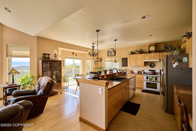 41293 Crested Crane St, Homer, AK 99603 - kitchen featuring white appliances, a sink, light brown cabinets, open floor plan, and a chandelier
