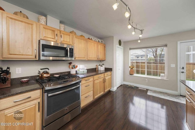 2823 Discovery Bay Dr, Anchorage, AK 99515 - kitchen with appliances with stainless steel finishes, light brown cabinetry, baseboards, dark wood-type flooring, and dark stone counters