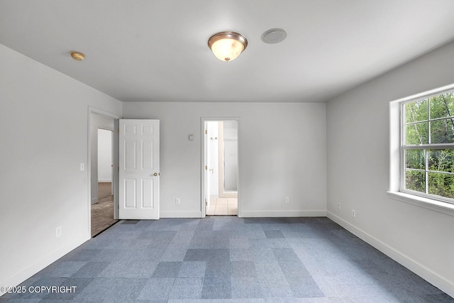 1151 W Gail Dr, Wasilla, AK 99654 - unfurnished bedroom featuring dark colored carpet, baseboards, and connected bathroom
