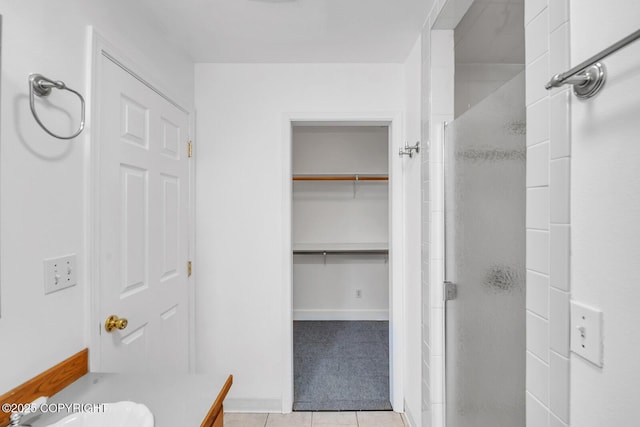1151 W Gail Dr, Wasilla, AK 99654 - full bathroom featuring a shower stall, tile patterned flooring, vanity, baseboards, and a walk in closet
