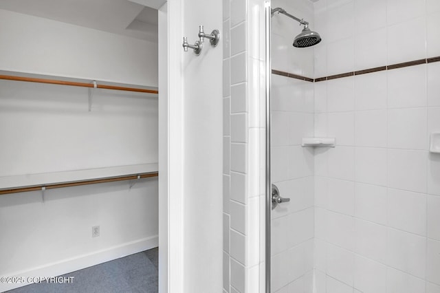 1151 W Gail Dr, Wasilla, AK 99654 - full bathroom featuring a shower stall, a walk in closet, and baseboards